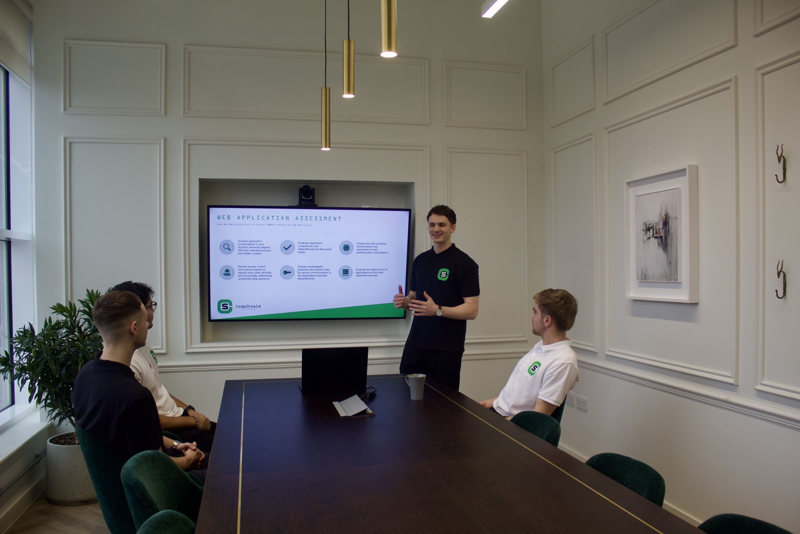 Man with codeshield shirt looking at screen of penetration testing report