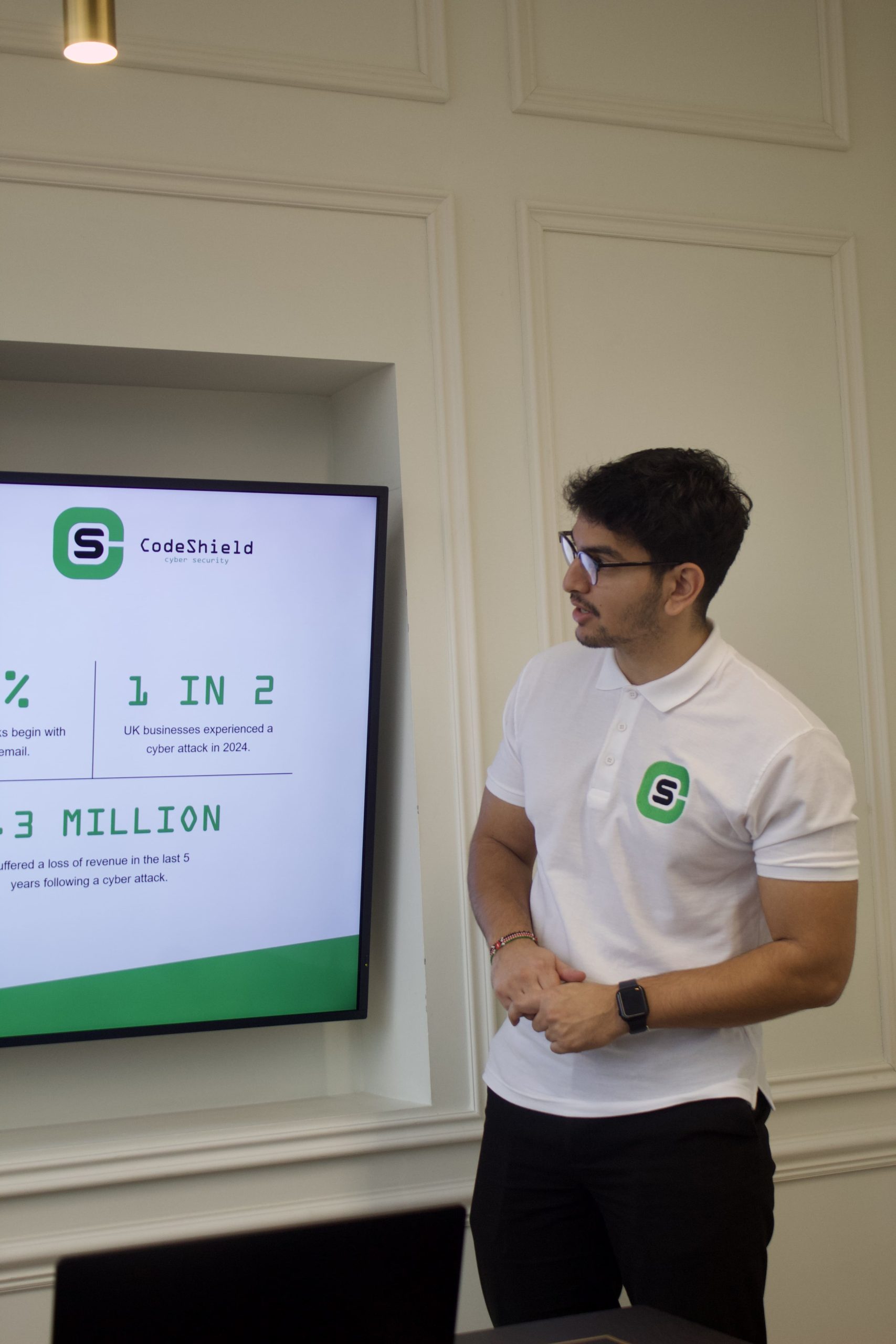Man with codeshield shirt looking at screen of penetration testing report